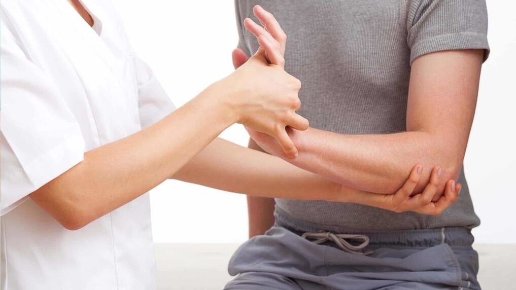 Dokter ënnersicht eng Hand mat Arthritis